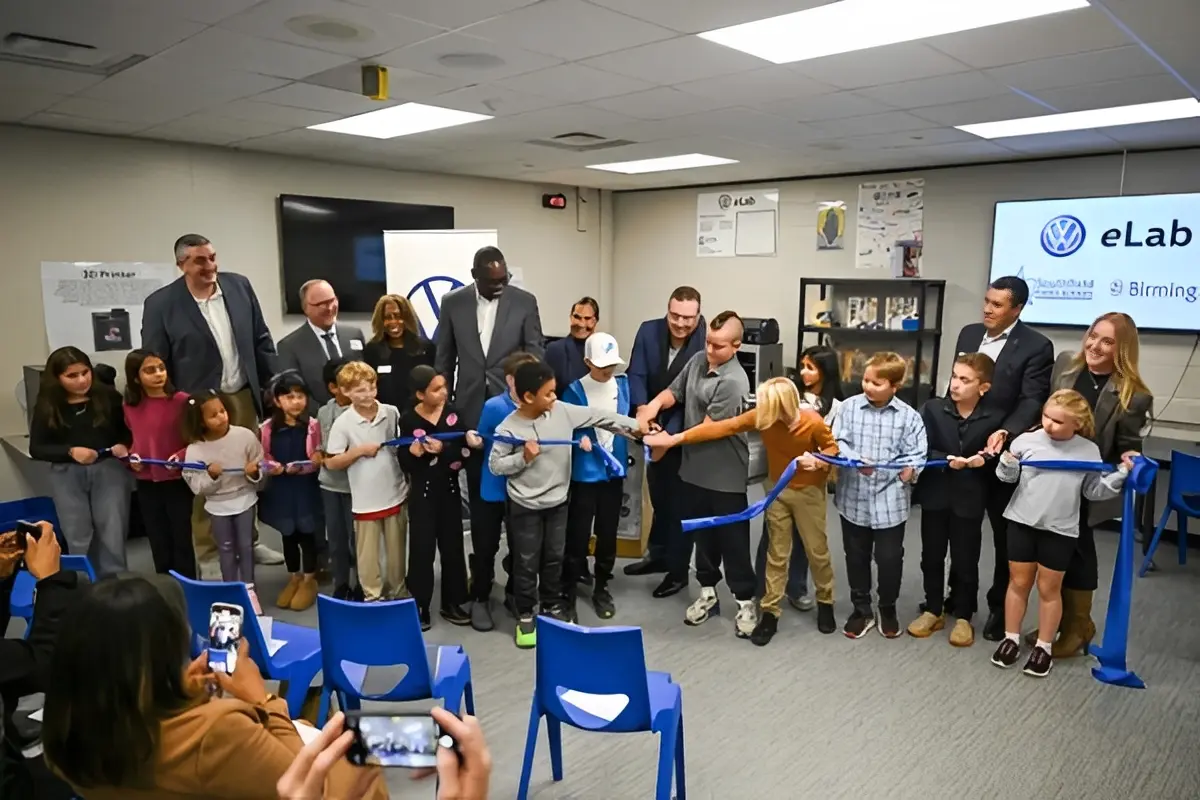 Children and adults cutting a ribbon in classroom
