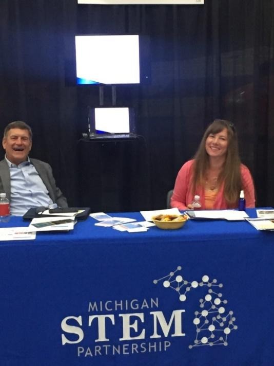 Michigan STEM Partnership booth with smiling representatives